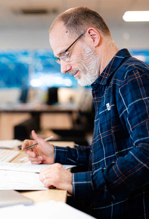 Alternative text - Un commercial travaille a son bureau sur un devis